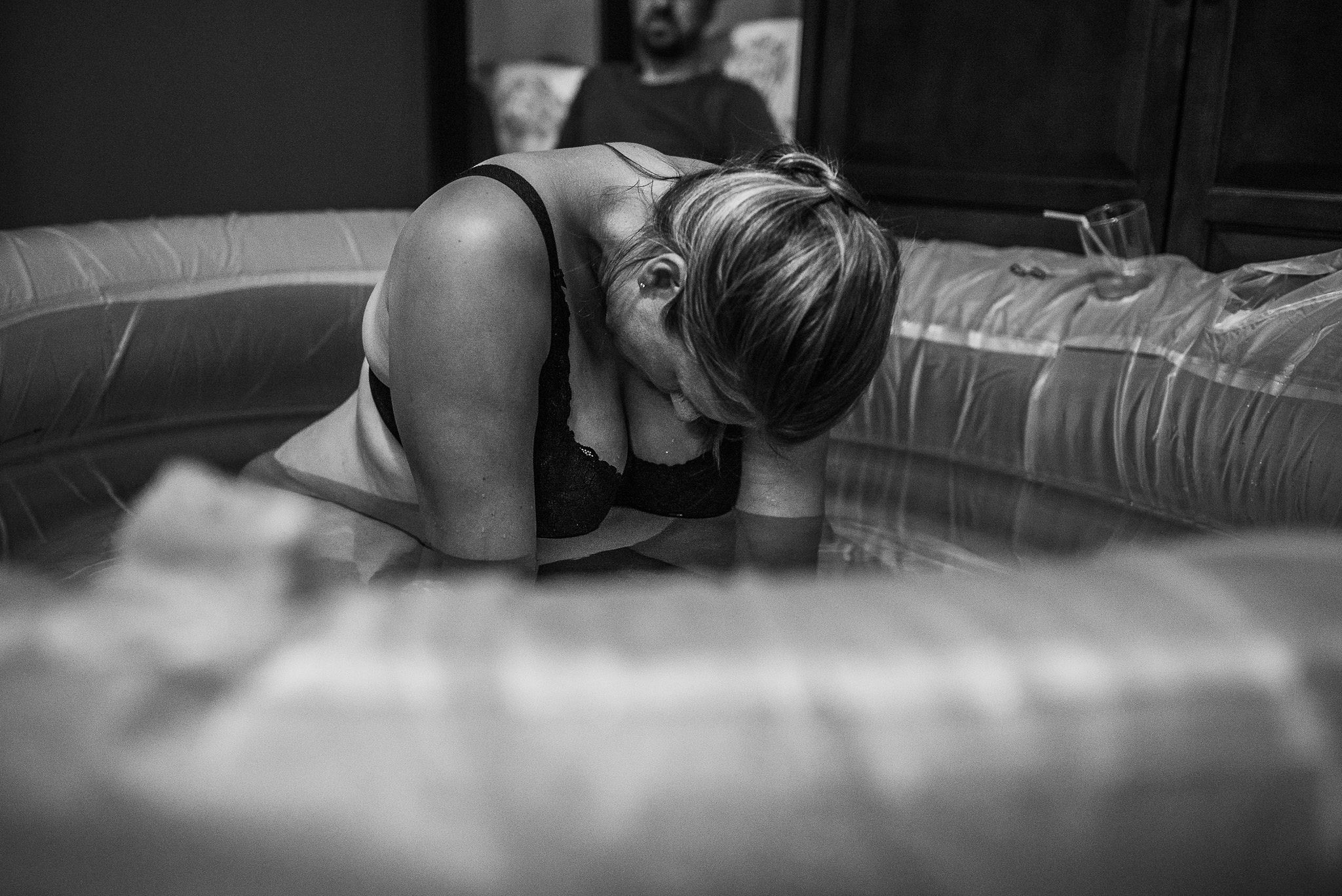 Woman leaning forward in an inflatable birth pool during labor