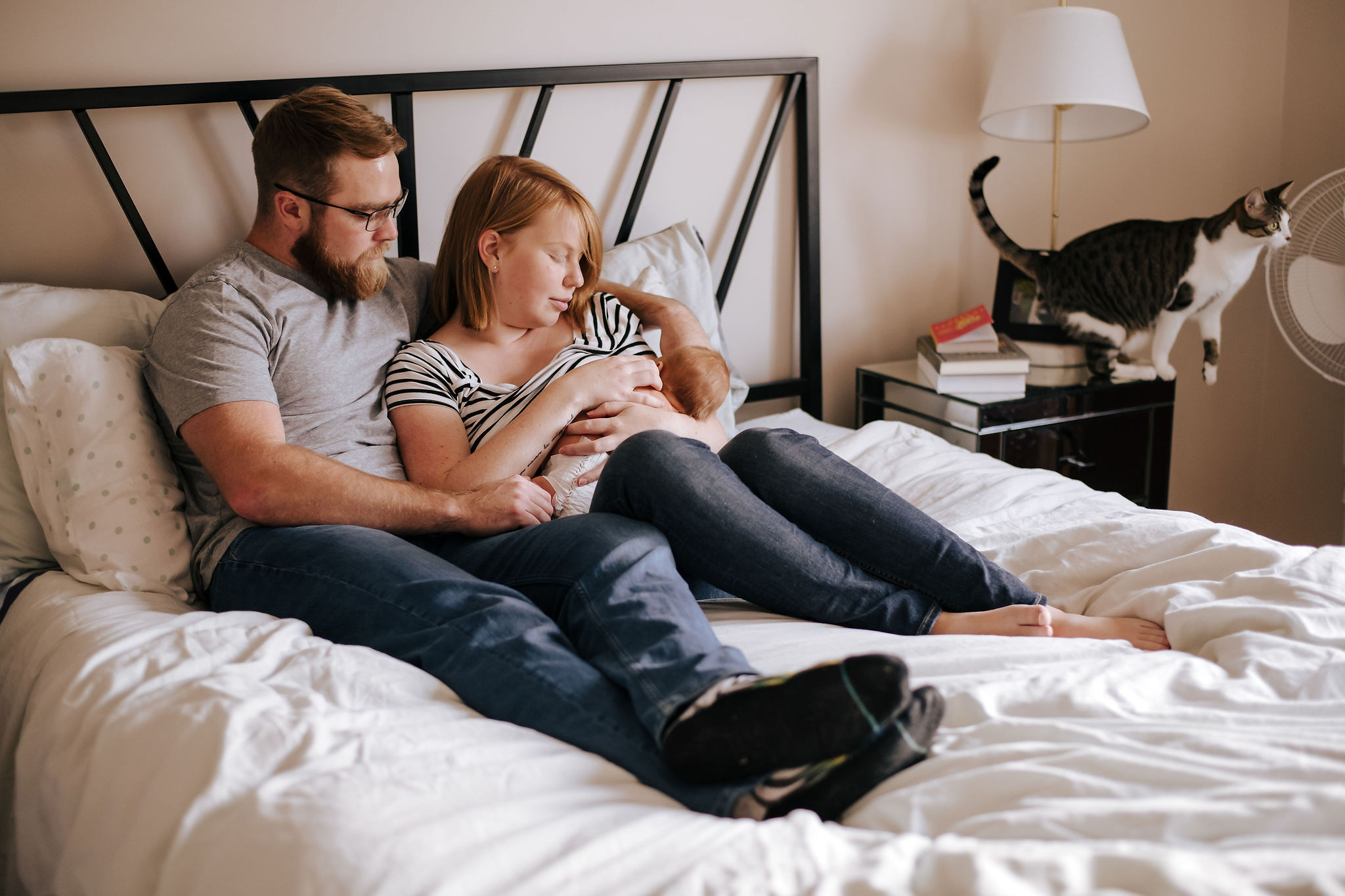 Parents resting together at home with their newborn